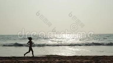 赤脚运动女孩跑步<strong>剪影</strong>沿着<strong>海浪</strong>游泳池跑步，保持身体健康。日落黑沙滩